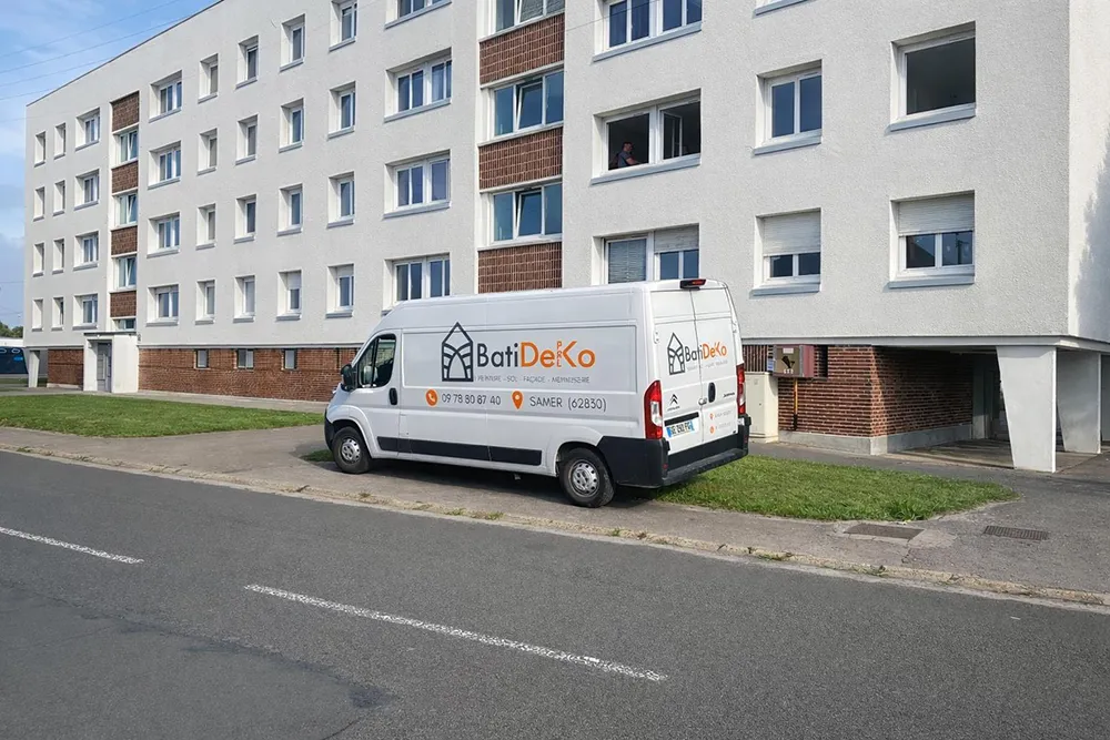 Camionnette BatiDeKo stationnée devant un immeuble