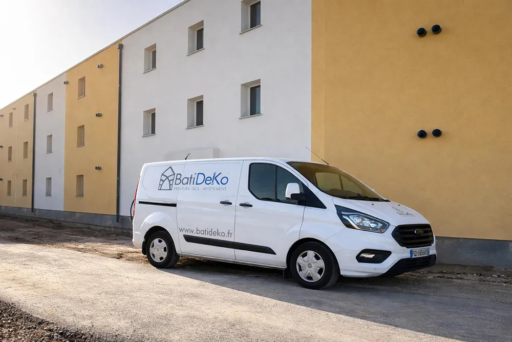Fourgon blanc BatiDeKo stationné devant un bâtiment