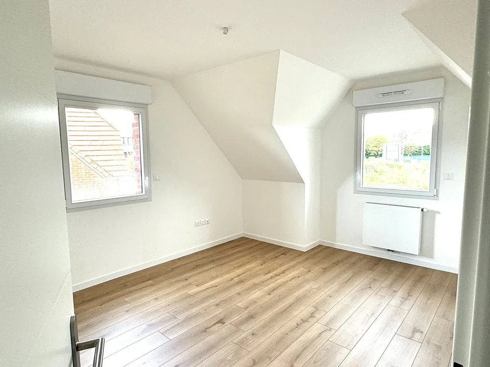 Pièce vide avec parquet et deux fenêtres